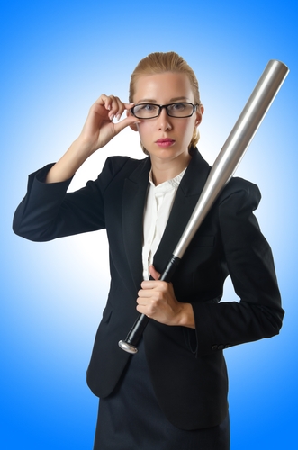 Businesswoman with baseball bat on white