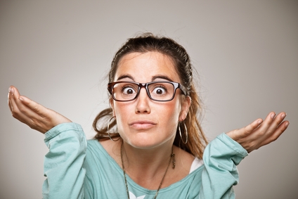 Shrugging woman in doubt doing shrug showing open palms.